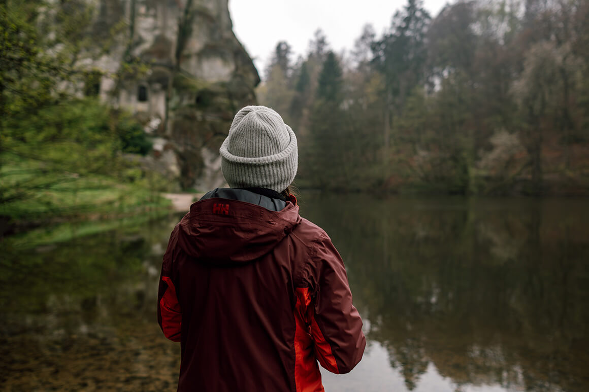 woman looking at a lake in the forest