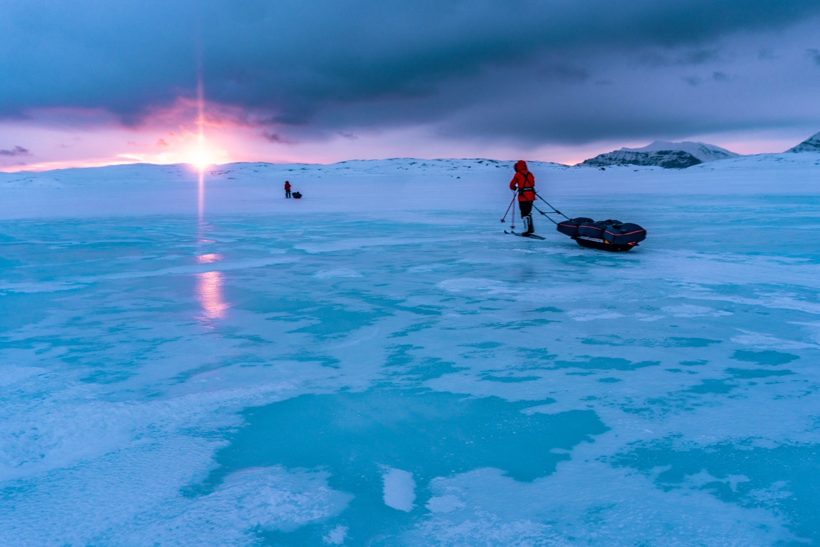 the scientists trekking across the ice, pulling their gear on sleighs 