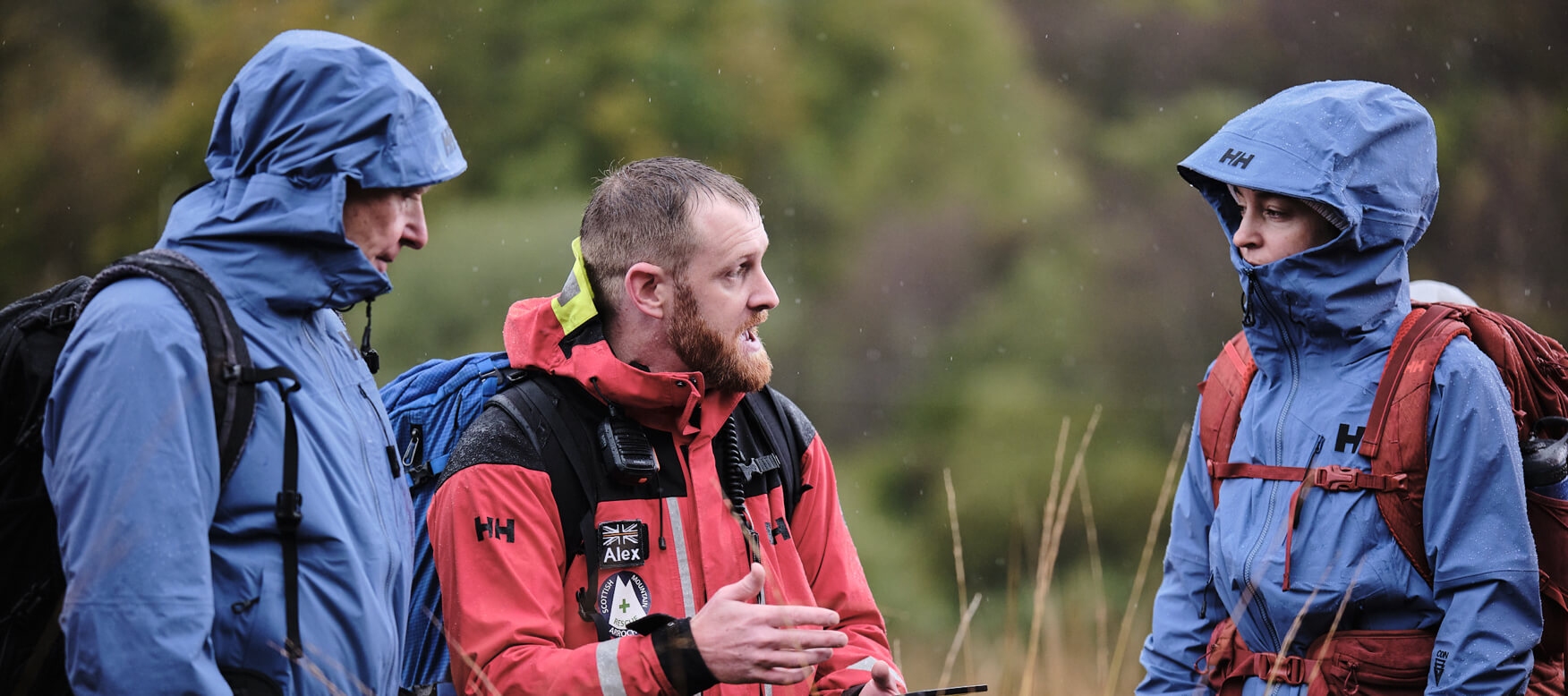 Rescue worker talking to two hikers in the outdoors