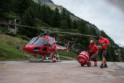 2 men loading up a helicopter 