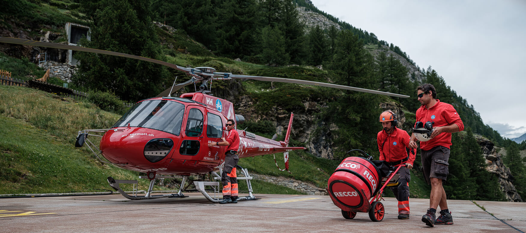 Men loading helicopter on mountain