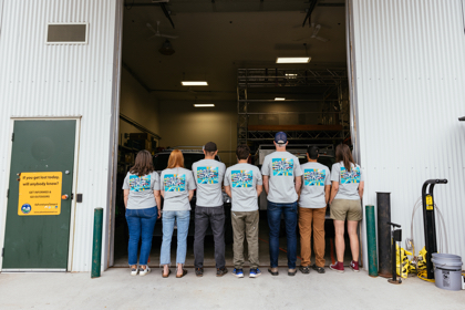 group of people standing with their backs to the camera with matching shirts on