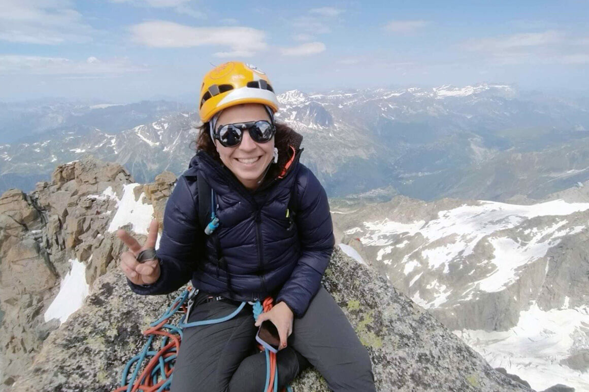 Woman sitting at the top of a mountain