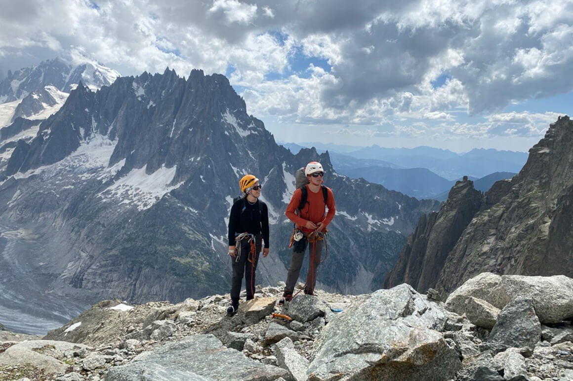 Two people standing on top of a mountain