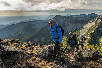 Three people hiking on a mountain ridge