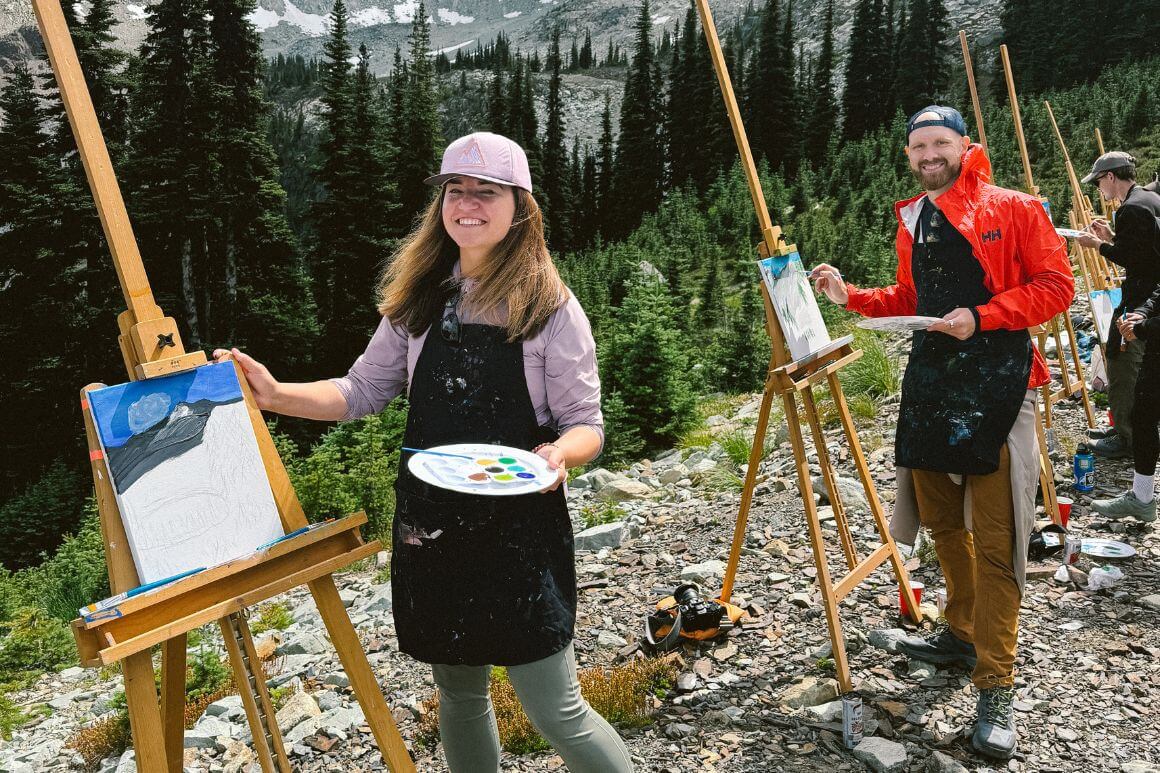 Andy and Anna painting in the mountain on easels 