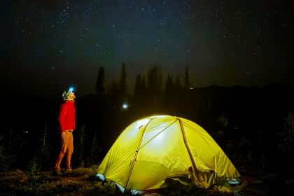 man watching the stars next to his tent at the summit sleepover event