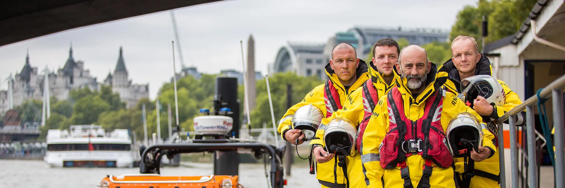 rnli team in their gear standing next to the pier