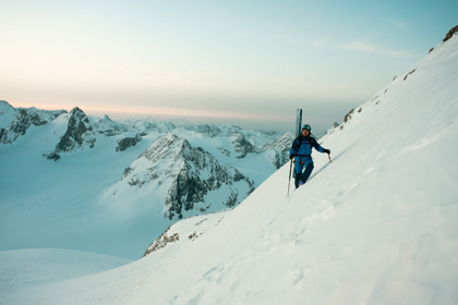 paul de groot hiking on a snowy mountain with skis on his back