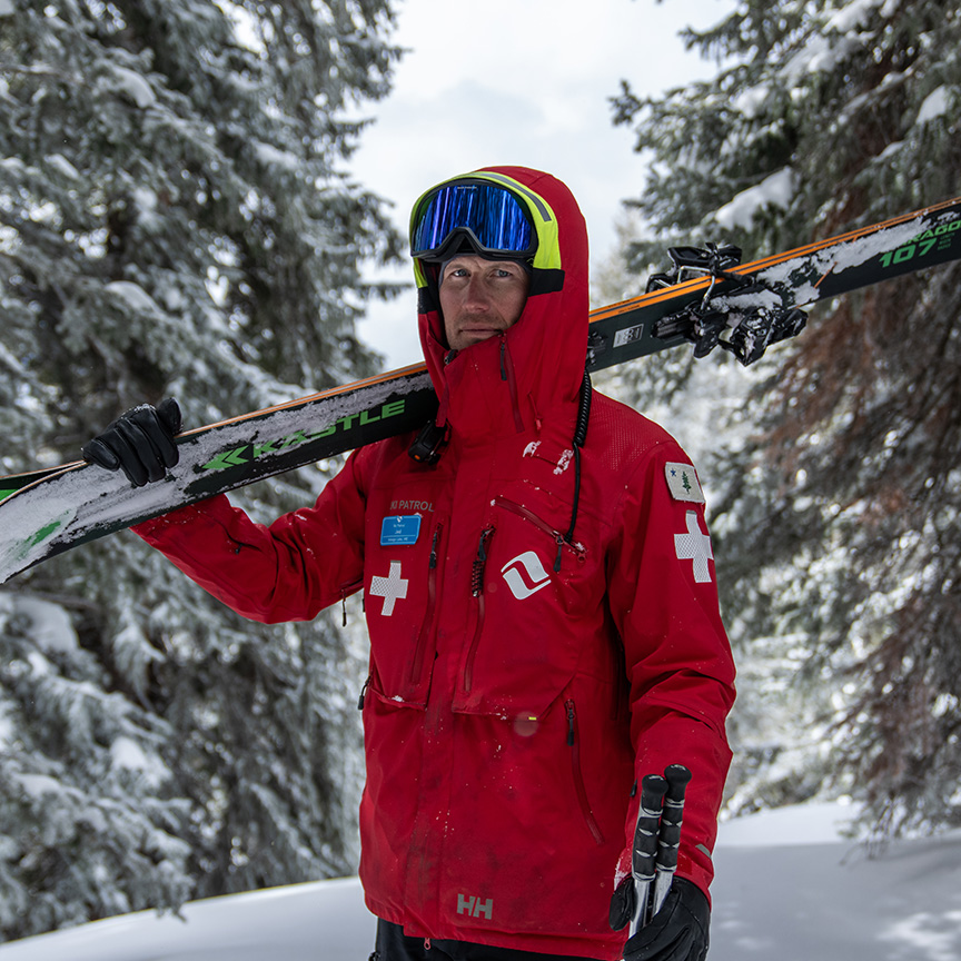 ski patroller carrying skis