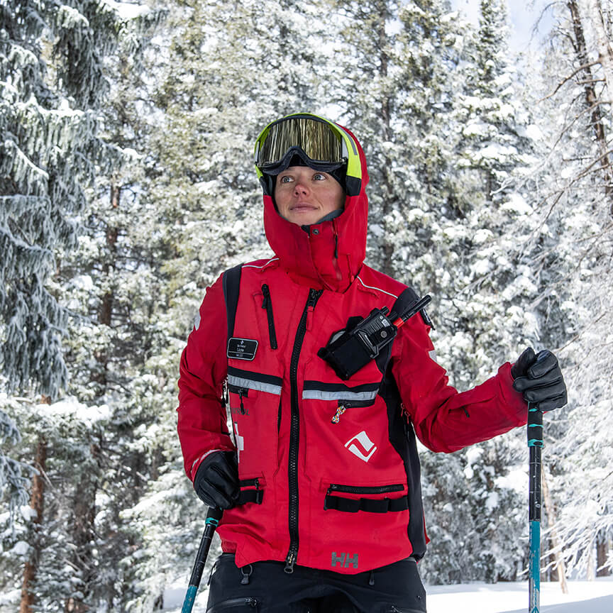 ski patroller standing in front of hut