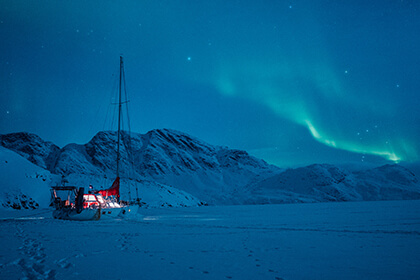 sailboat with northern lights in the background