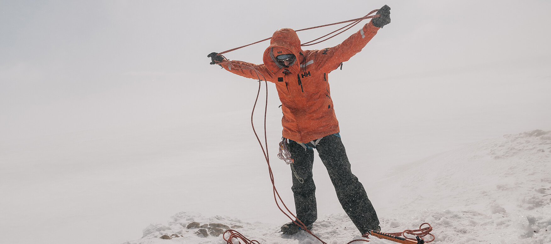 Man organizing a climbing rope in a blizzard 