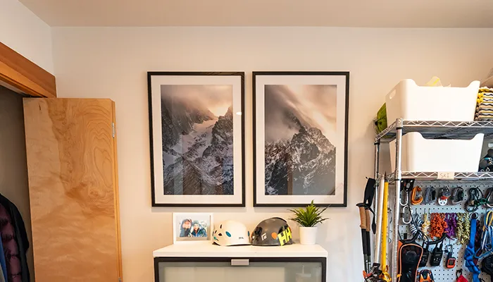 posters of mountains in a room with organised outdoor gear