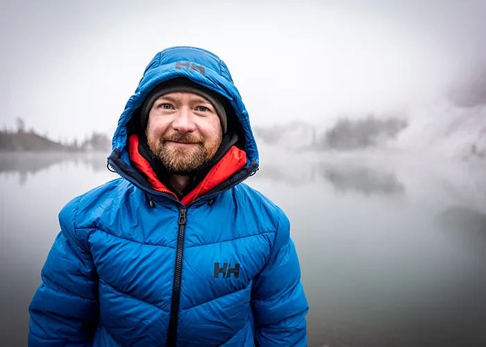 nate brown smiling in front of a lake