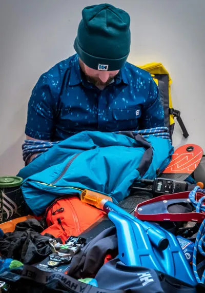 person in a pile of outdoor gear