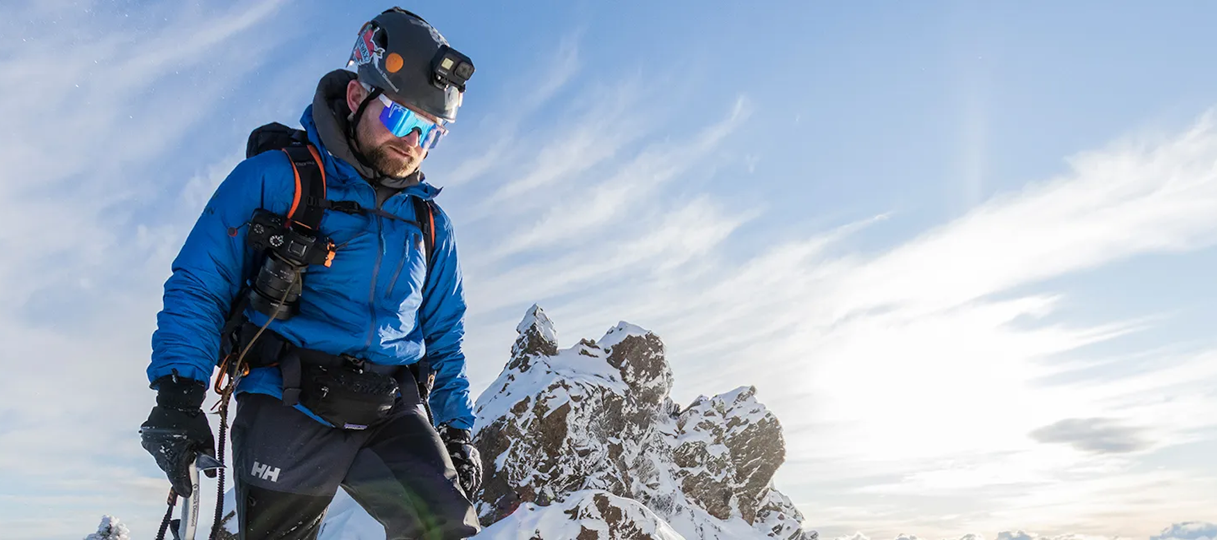 man summiting a mountain in ski gear