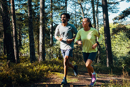 two people trail running in the forest