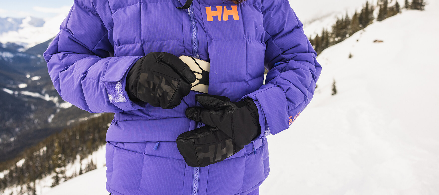 skier placing cell phone in a pocket