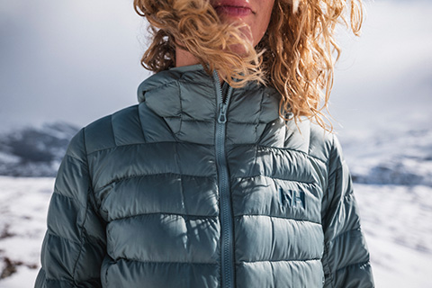 A woman standing outside wearing a clean down jacket.