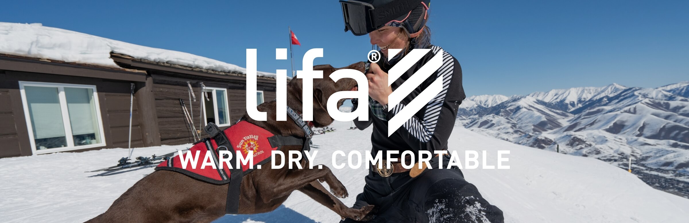 ski patroller with a dog in helly hansen base layers