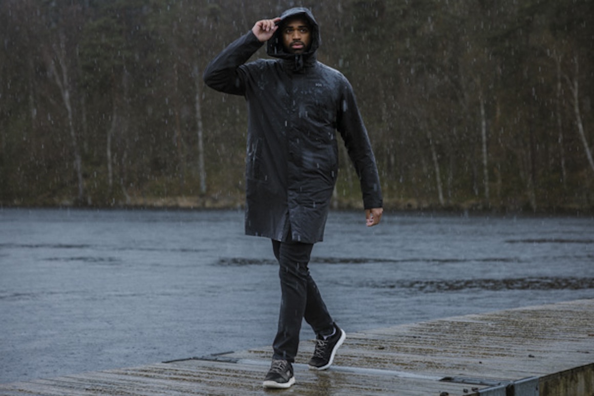 man standing on the water's edge wearing a jacket with helly tech technology