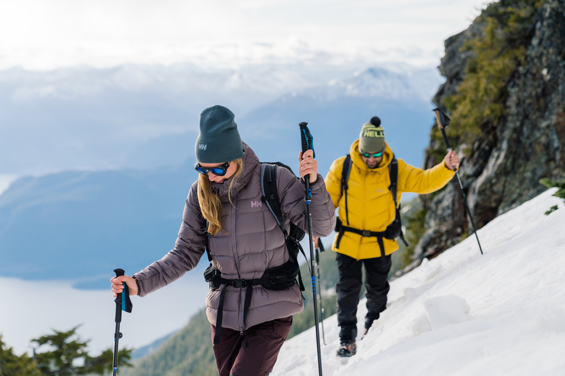 2 people hiking with backpacks in down jackets