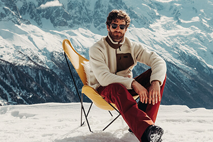 man sitting in a chair in the mountains
