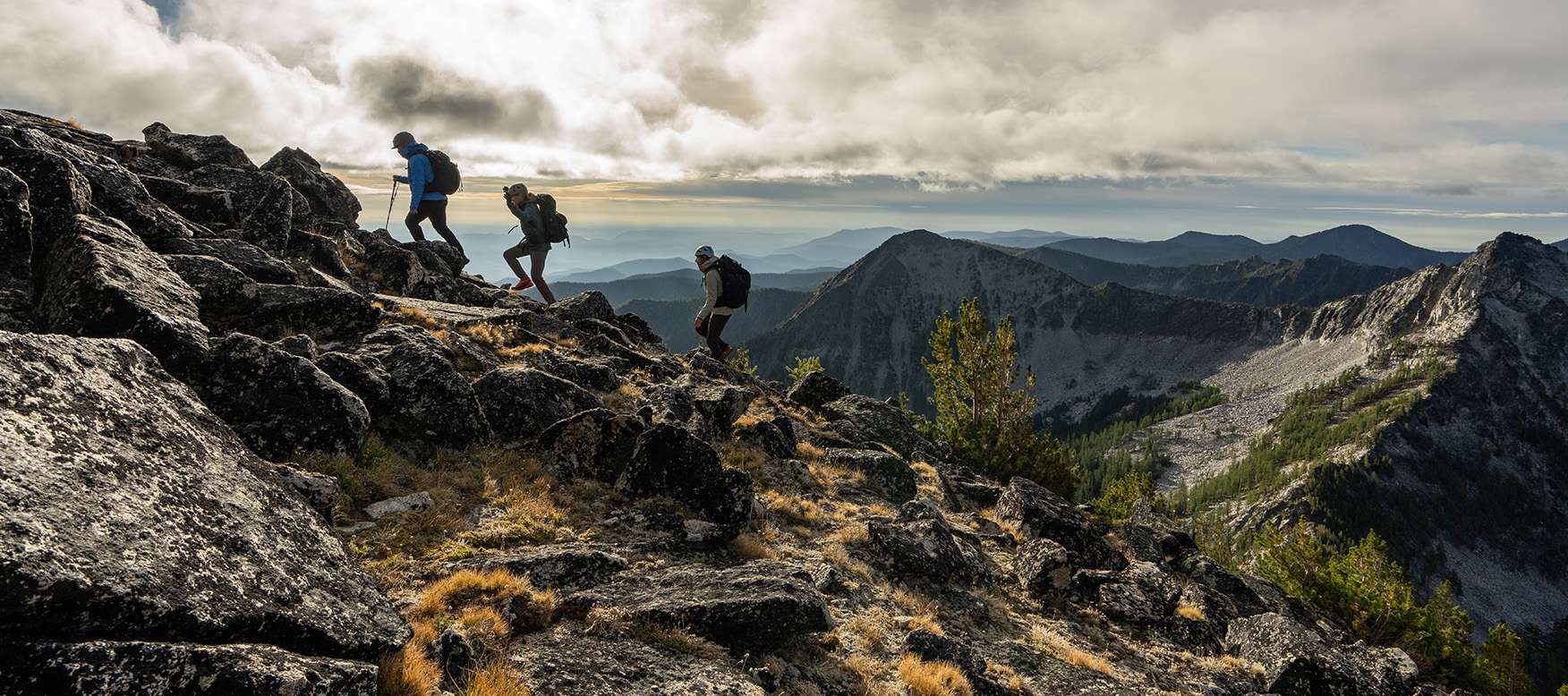 3 backpackers hiking up a mountain