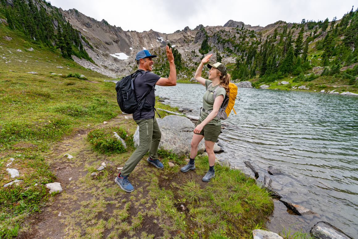 2 people high fiving on the mountain