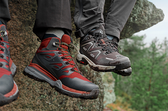 2 pairs of shoes dangling from a cliff face.