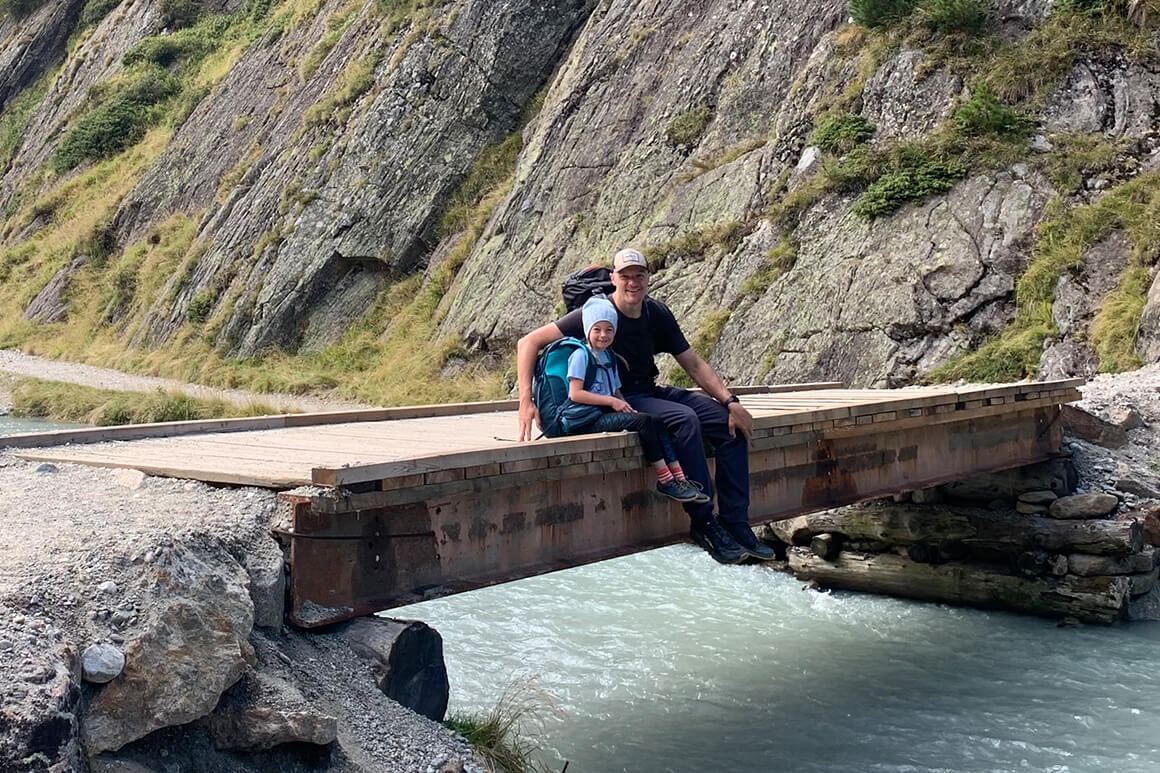 Joel and his daughter, Marjorie stop for a rest on a bridge with a river flowing underneath