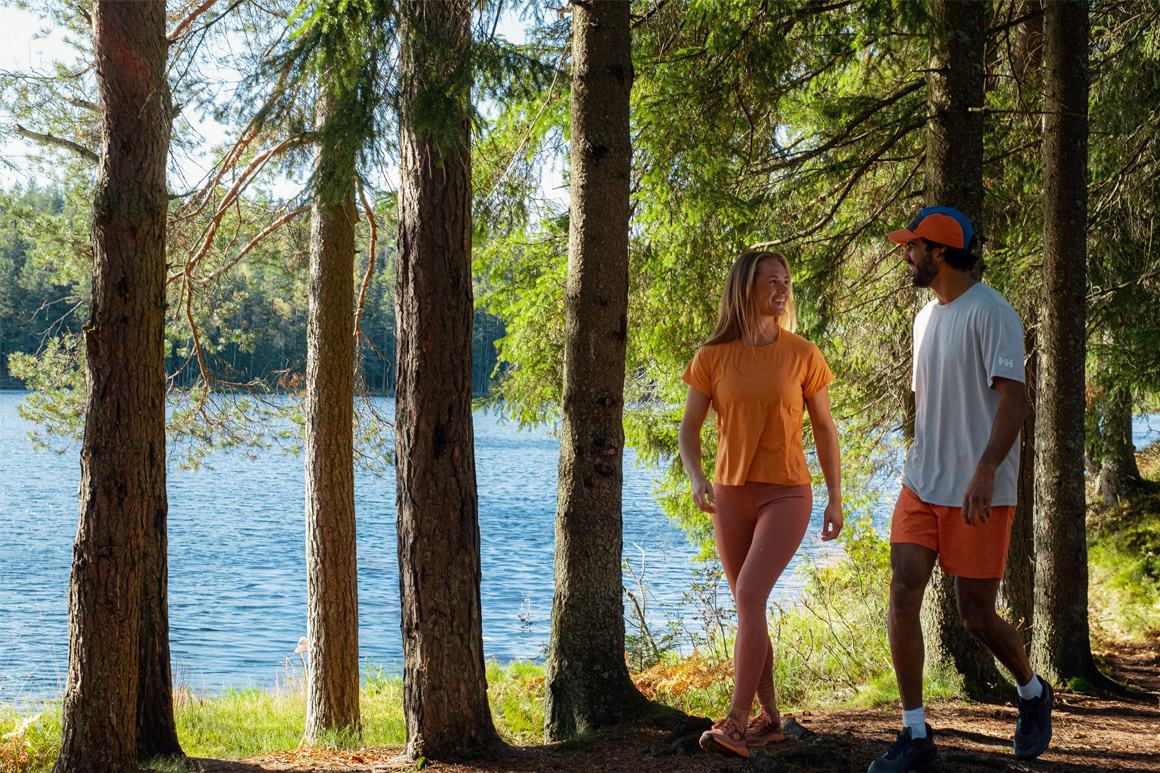 Man and woman walking by a lake in the sun