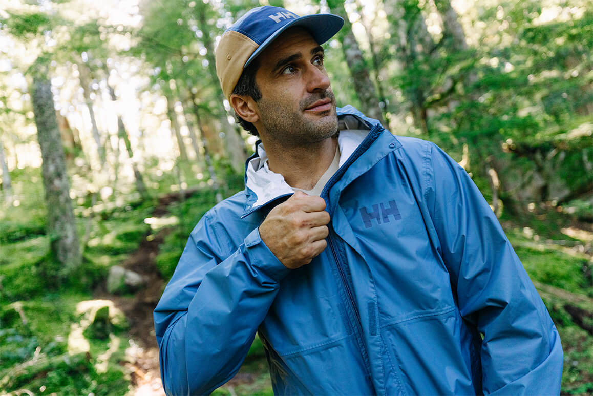 Man zipping up his jacket in the forest