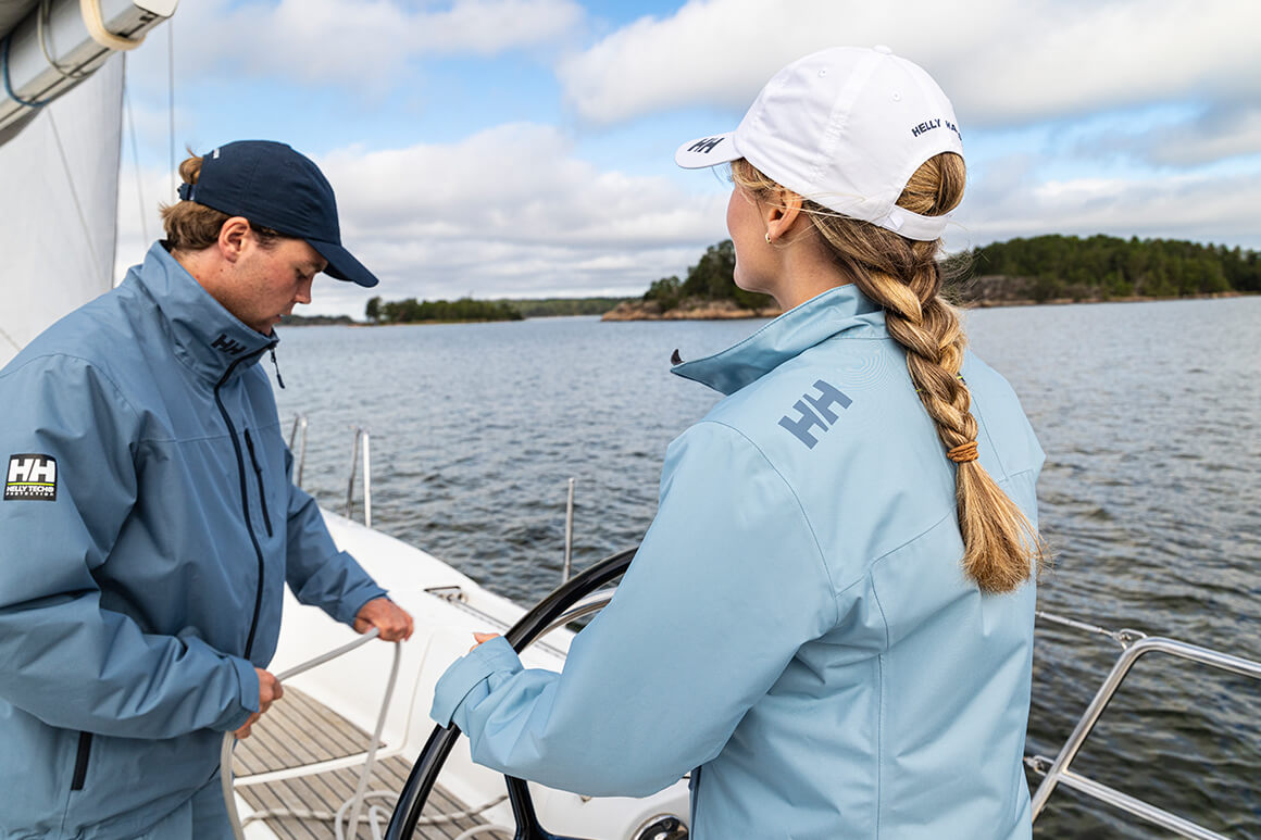 man and woman in blue jackets on board a sailing boat