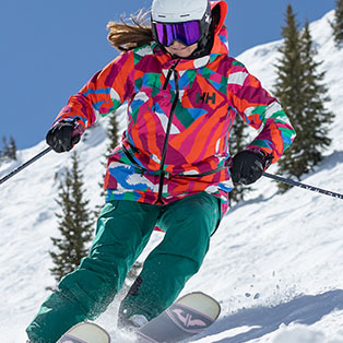 A woman wearing a colorful ski jacket.