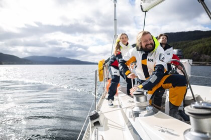 Man and woman sailing in the Newport Coastal Jacket