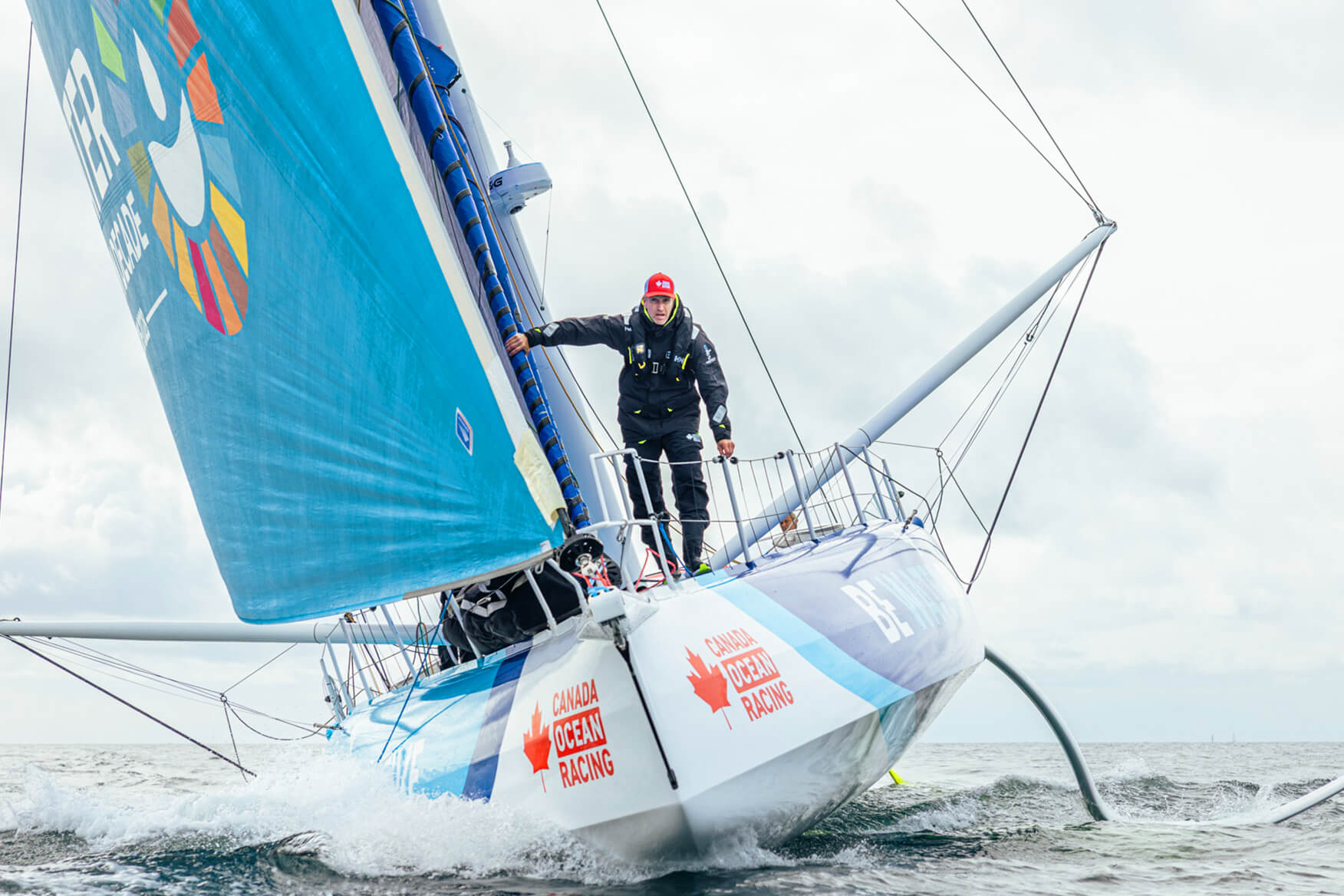 Two sailors on the deck of an IMOCA sailing boat