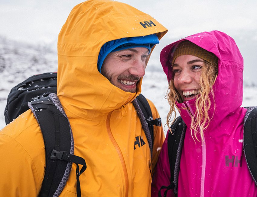 Two hikers laughing outside in snowy terrain